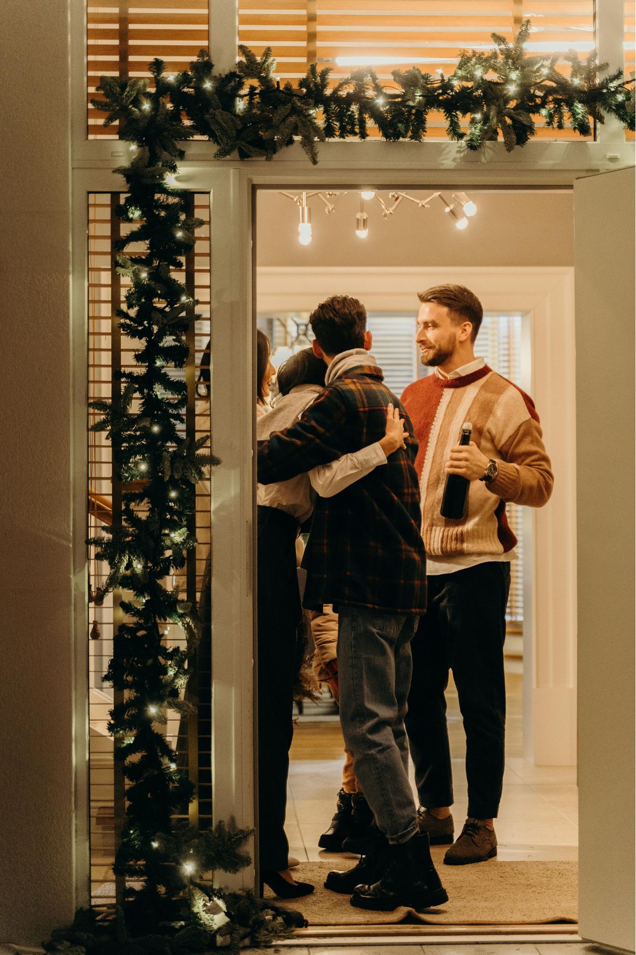 people entering a home and hugging in the entryway